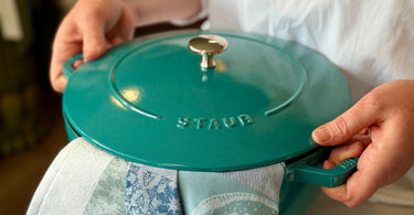 Woman holding a green dutch oven