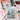 Painting kit with sailboat painting, brushes, and flowers on a table