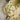 White flowers with yellow centers on a beige fabric and wooden plate against a concrete background