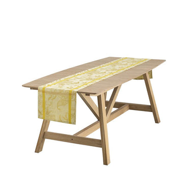 Wooden table with a yellow patterned table runner on a white background