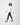 Image features model wearing white tuxedo ruffle shirt and dark blue jeans. This image is a side profile.