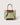 A structured tote bag in light sage green canvas with contrasting brown leather trim, double top handles, and a matching brown base panel, shown against a solid light beige background.