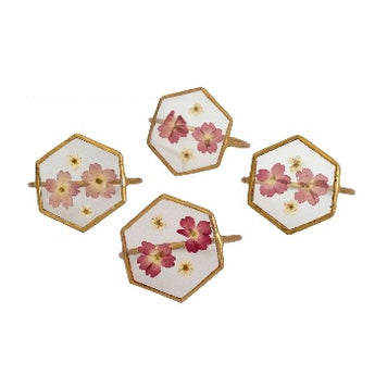 Brass hexagonal napkin ring with pressed flowers in center