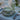 Vila Dinnerware Collection in Olive and Blue shown as a place setting on a table with silverware and drink ware.