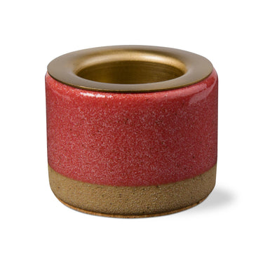 Cylindrical ceramic holder with red glaze and gold accents on a white background