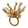 A statement napkin ring featuring a textured gold-toned band adorned with a dramatic, fan-like arrangement of clear and amber-orange glass leaves on a white background.