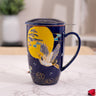 Navy blue mug with a yellow moon and crane design; sitting on a marble surface.
