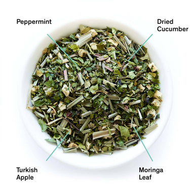 Herbal mix in a bowl with labels for peppermint, dried cucumber, Turkish apple, and moringa leaf.