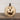 Decorative pumpkin with a carved face on a wooden surface against a white wall.