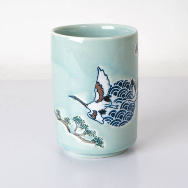 Ceramic mug with bird and wave design on a light blue background