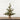Small potted Christmas tree with pinecones on a wooden surface and white wooden panel background
