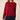 A woman wearing a long-sleeve knit sweater in deep burgundy red, paired with dark blue jeans, shown from the side against a plain beige background.