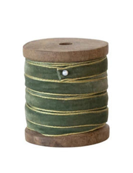 Wood spool with green velvet ribbon trimmed in a gold metallic edge, secured with a pin