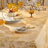 Decorative table setting with floral-patterned tablecloth, glasses, and plates.