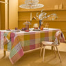 Dining room with a checkered tablecloth, chairs, and decorative elements.