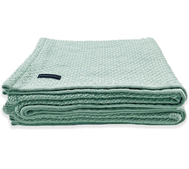 Image is Faribault Mill’s Bar Harbor blanket in Surf, folded neatly - side profile.