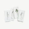 Four white napkins with botanical illustrations on a white background
