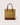 A structured tote bag with a textured mustard-yellow body, brown leather handles, and a brown leather base, shown against a light gray background.