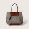 A gray felt tote bag with brown leather handles and trim, shown against a light gray background.