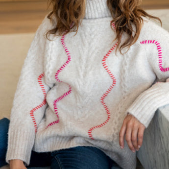 Neutral almond chunky knit sweater with mock turtleneck and pink contrast stitching