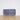 A rectangular clutch purse with a dark blue and white textured pattern, displayed on a small clear stand on a light wooden surface against a white wall.