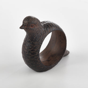 Bronze bird-shaped napkin ring on a white background