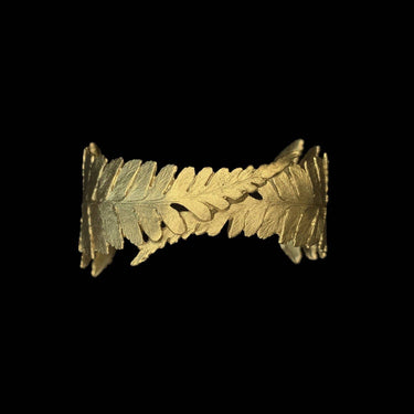 Gold leaf-patterned object on a black background