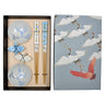 Serving set with bowls, chopsticks, and a box featuring crane designs on a light blue background.