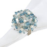 Decorative napkin ring with blue floral design and pearl-like stones on a white background