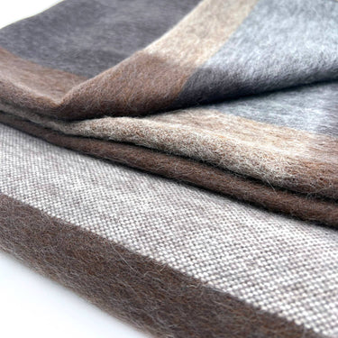 Stack of gray, brown, and beige fabric swatches on a white background