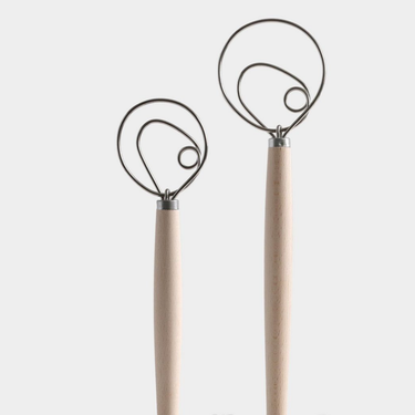 Two metal whisks with wooden handles on a white background
